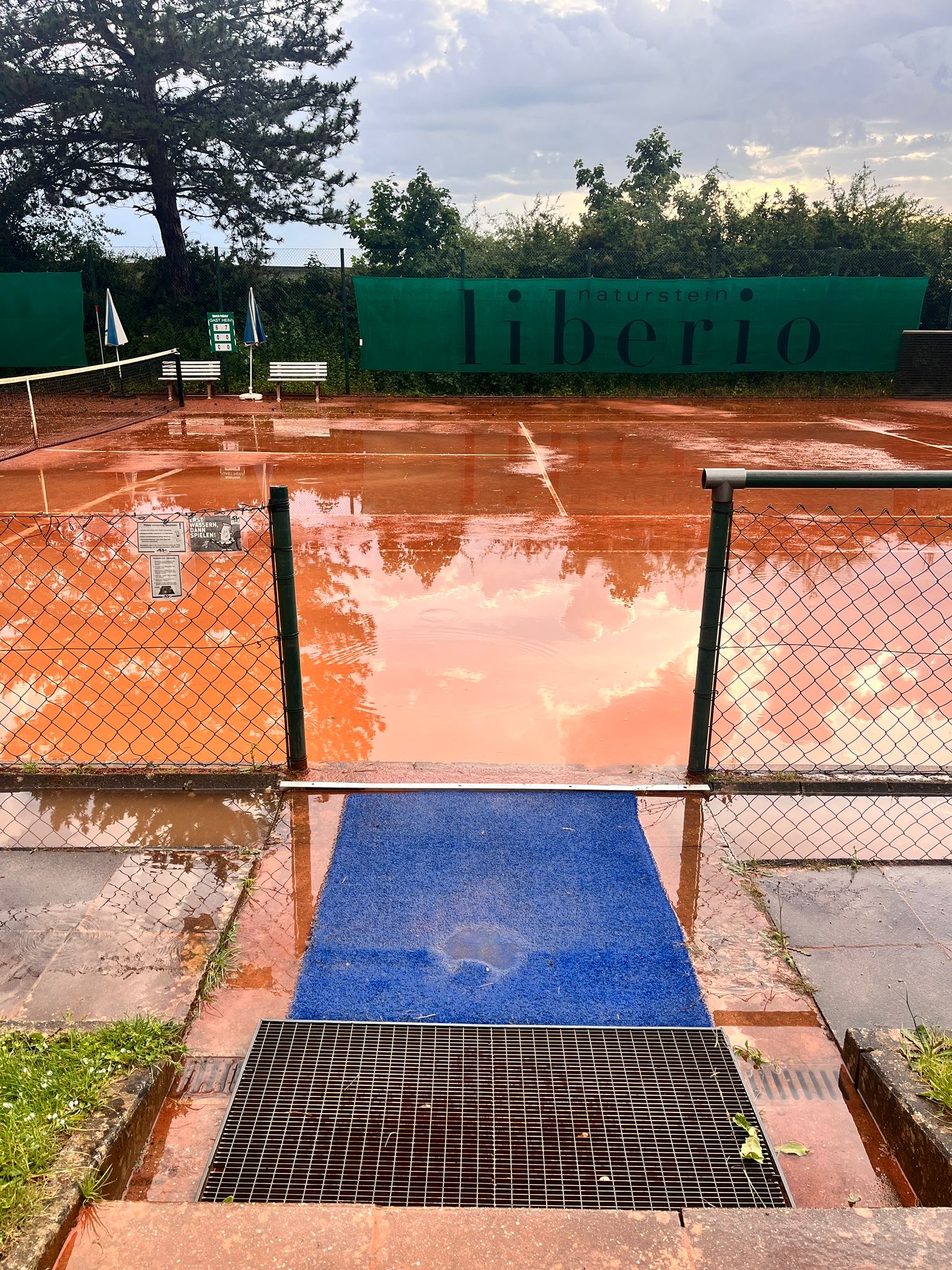Überfluteter Sandplatz nach dem Gewitter